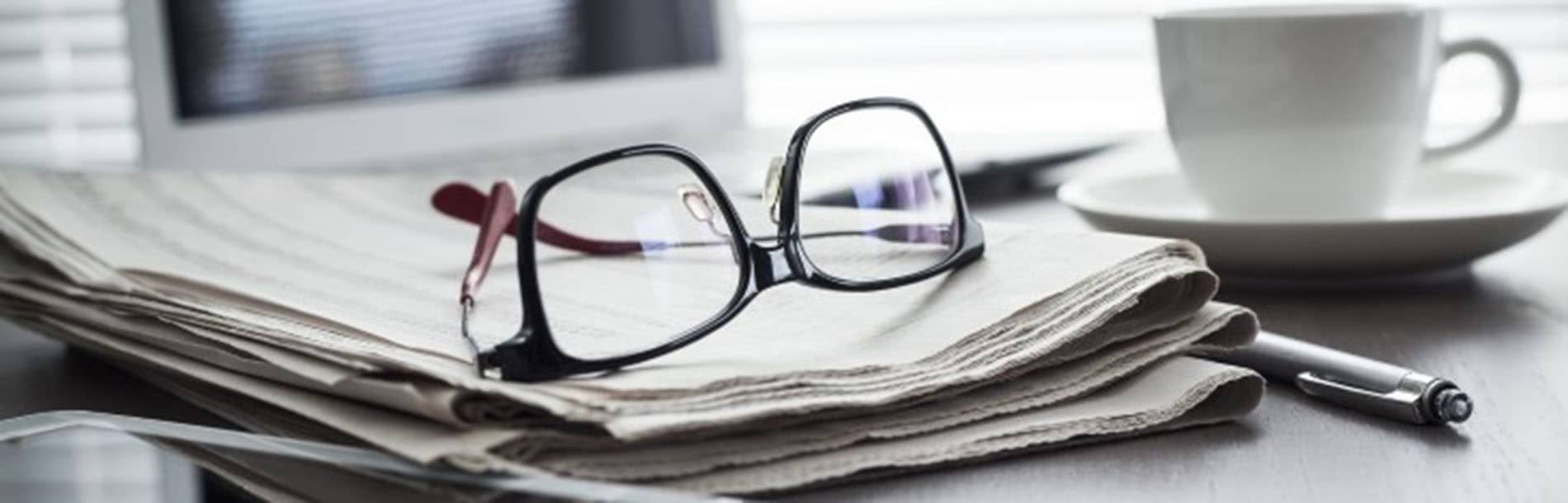 reading glasses resting on newspaper