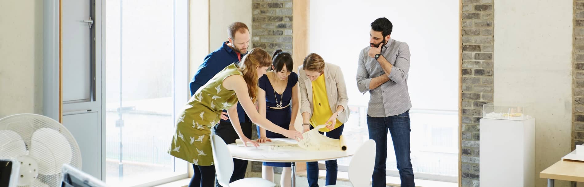 Group of workers looking at papers on a desk
