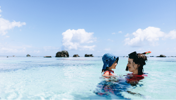 Woman and young daughter swimming in the sea on holiday