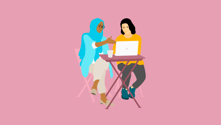 2 women sitting together working on a laptop