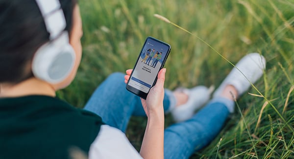 Woman sitting on grass looking at a phone