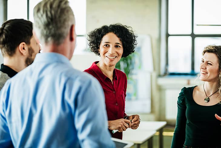 people standing talking in meeting