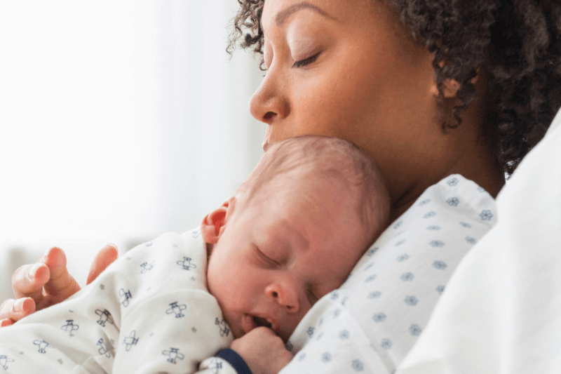 baby sleeping on woman's chest